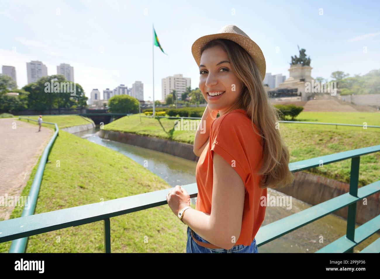 Belle fille regardant la caméra avec le drapeau national brésilien et Sao Paulo paysage urbain sur le fond, Brésil Banque D'Images