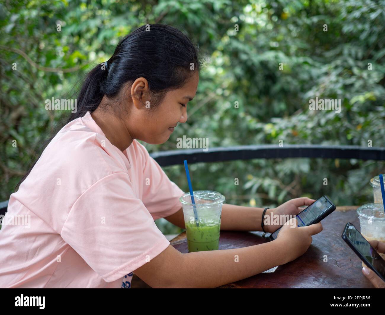 Femme regardant l'écran du téléphone dans le café Banque D'Images