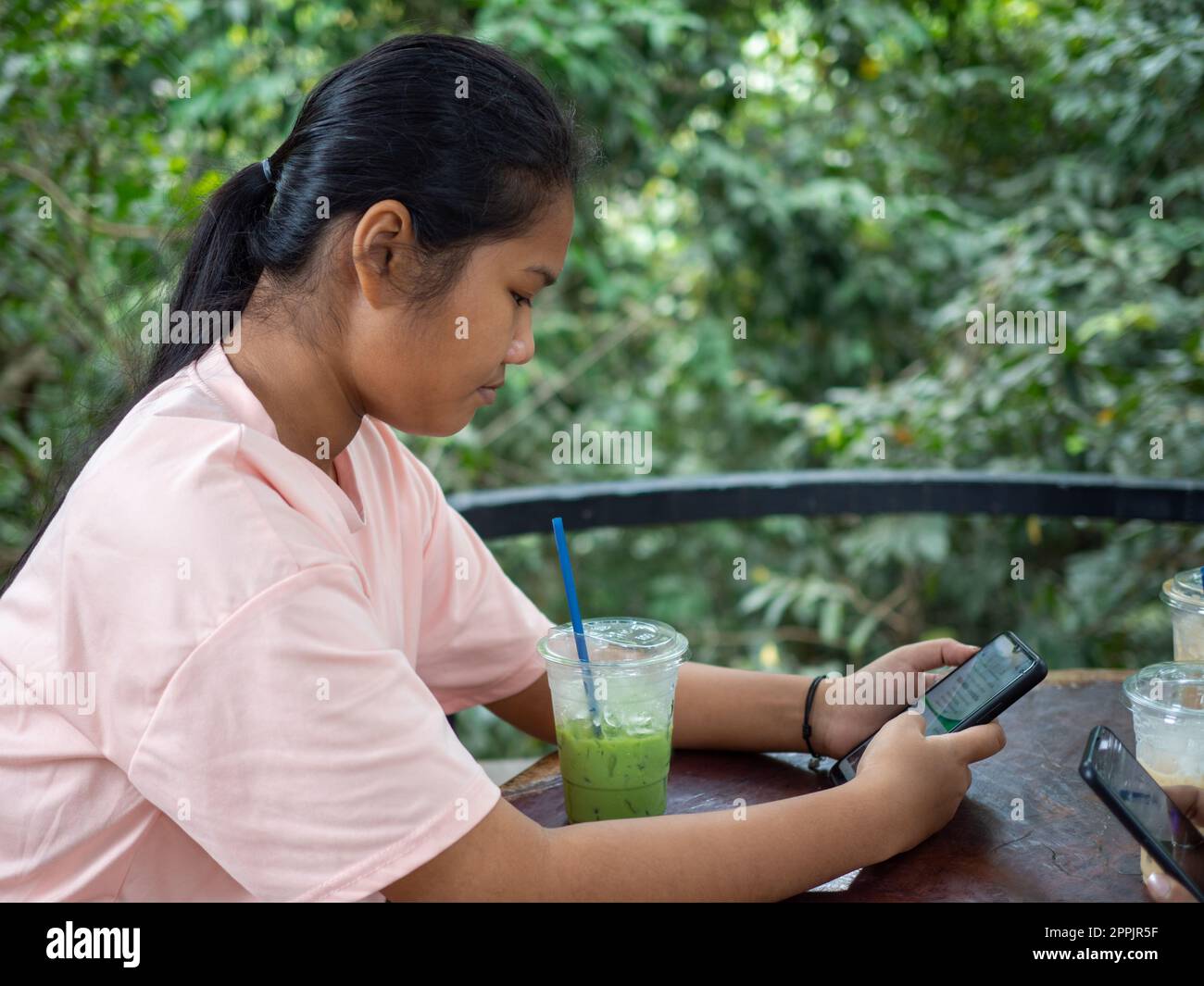Femme regardant l'écran du téléphone dans le café Banque D'Images