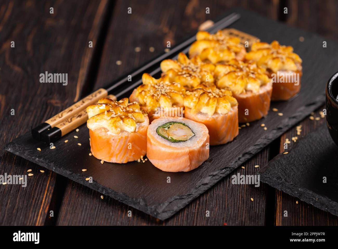 Rouler avec des sushis de poisson avec des baguettes - concept alimentaire asiatique Banque D'Images