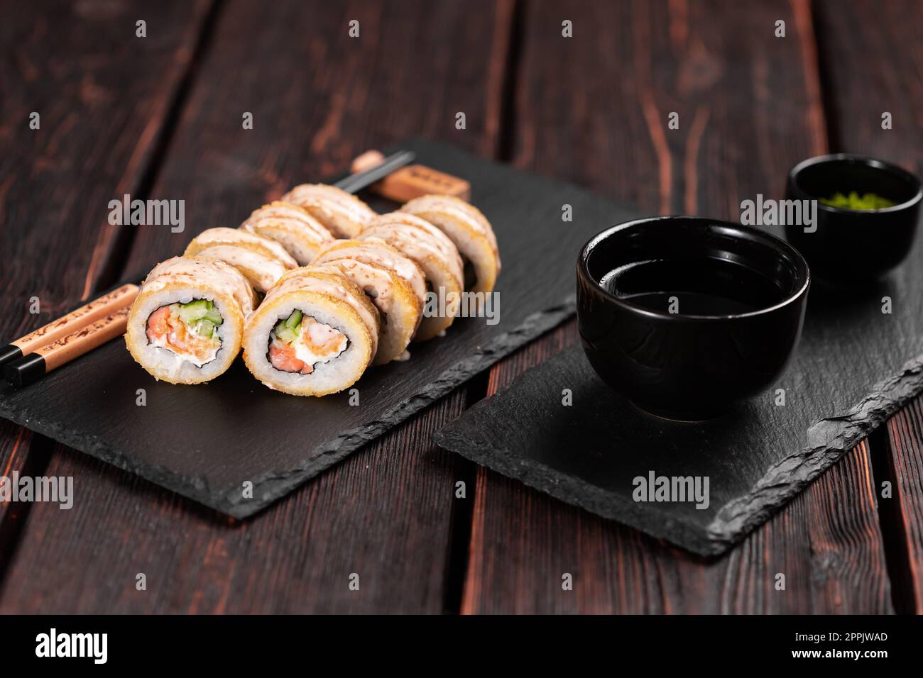 Rouler avec des sushis de poisson avec des baguettes - concept alimentaire asiatique Banque D'Images