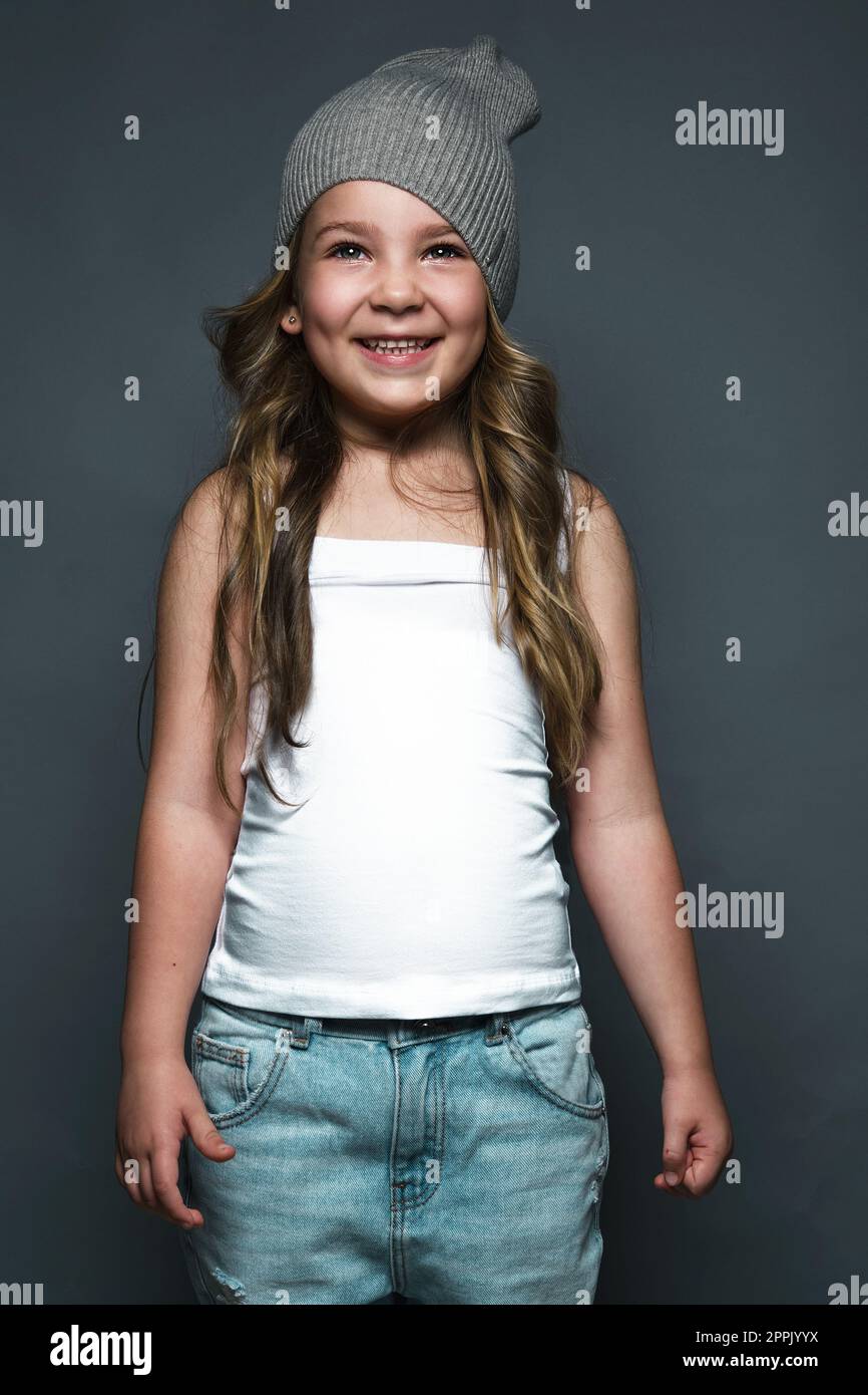 Petite fille modèle professionnellement posant dans le studio en jeans et un T-shirt blanc. Tests de modèles Banque D'Images