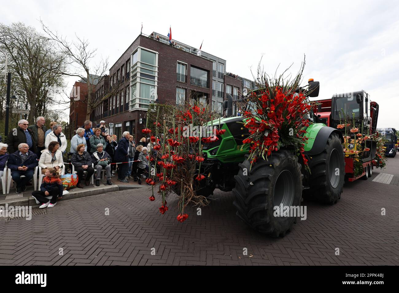 Un tracteur vert décoré de fleurs rouges au Flower Parade Bollenstreek Banque D'Images