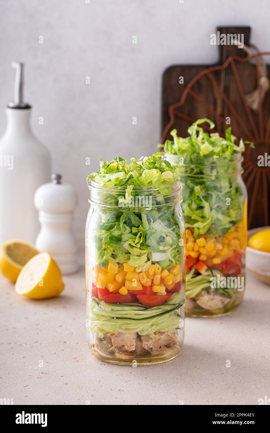 Préparation du repas de salade dans un bocal, légumes frais et salade de maïs avec poulet Banque D'Images