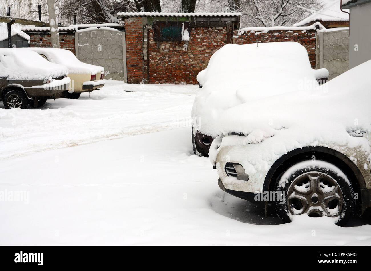 Fragment de la voiture sous une couche de neige après une forte chute de neige. La carrosserie de la voiture est recouverte de neige blanche Banque D'Images