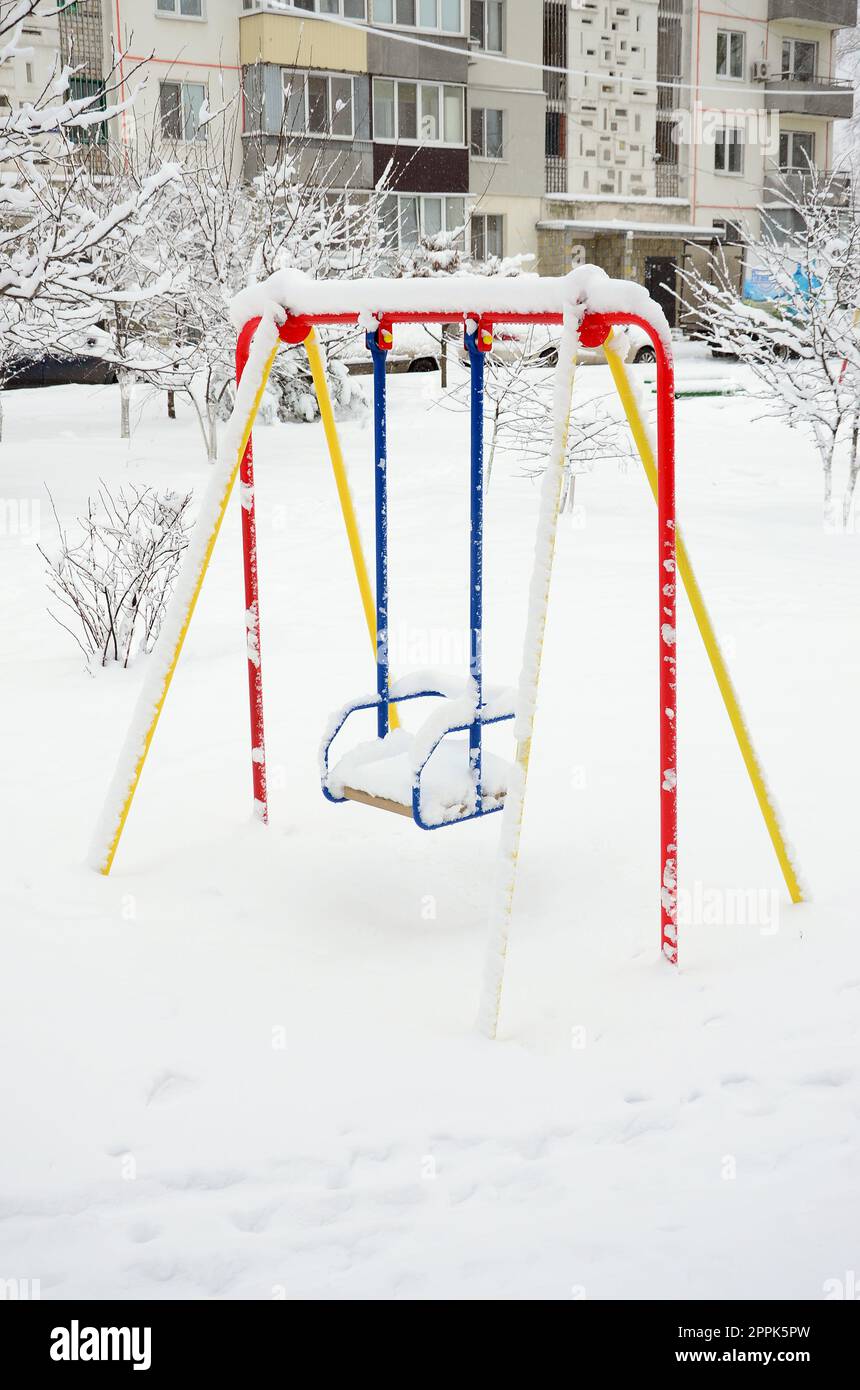 Balançoire pour enfants, recouverte d'une épaisse couche de neige après une forte chute de neige Banque D'Images