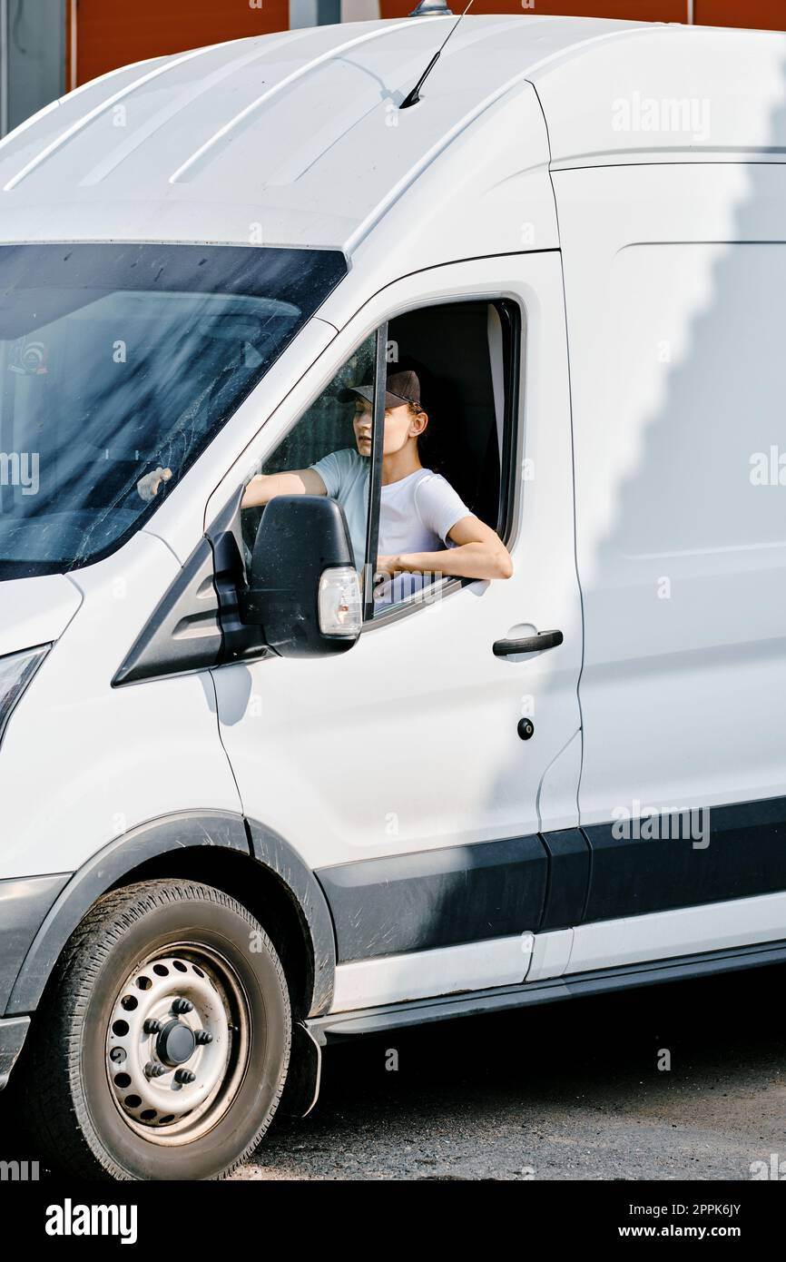 Jeune femme coursier conduisant un van Banque D'Images