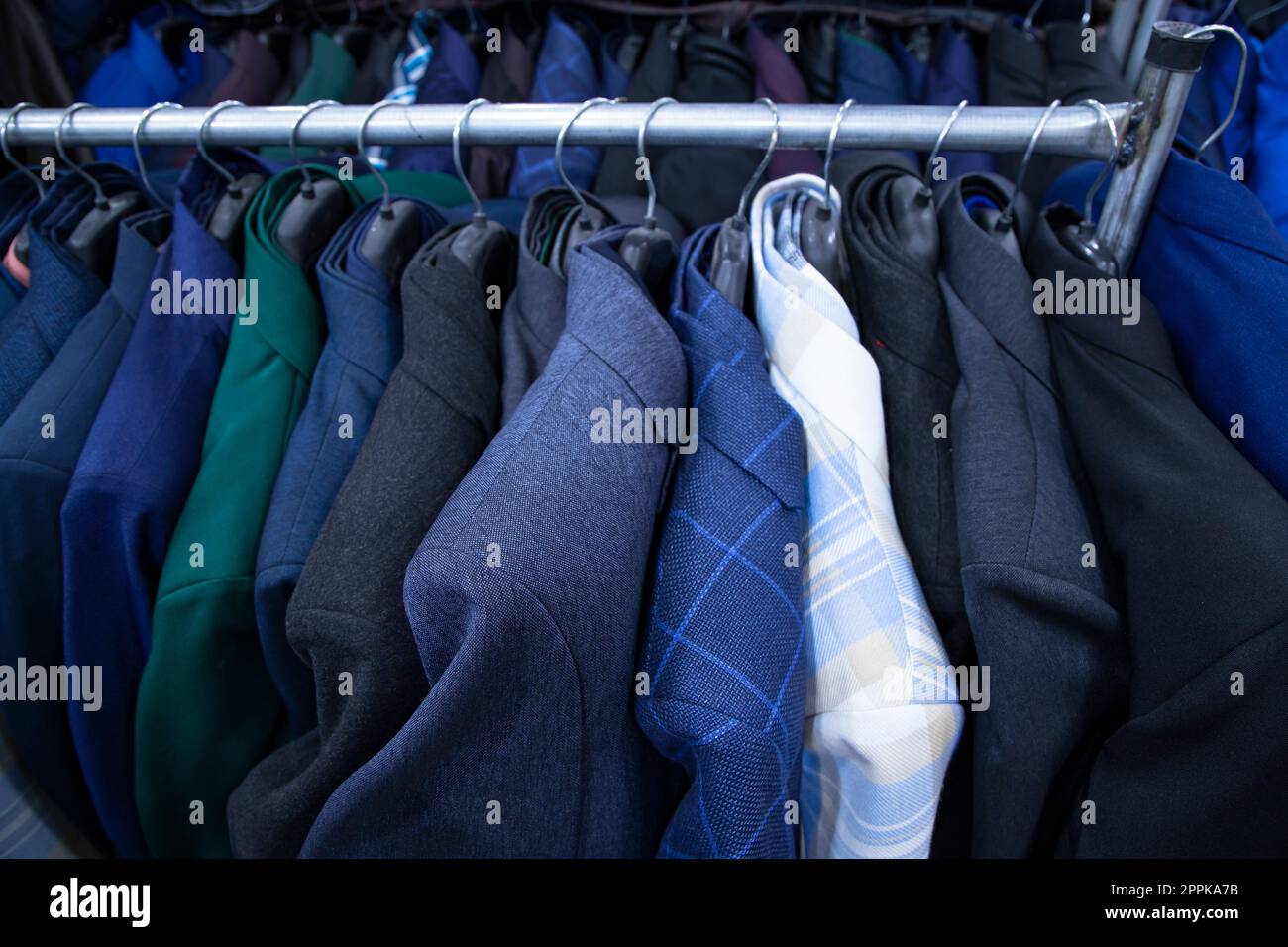 Vêtements pour hommes sur cintres dans un magasin, gros plan de la photo Banque D'Images