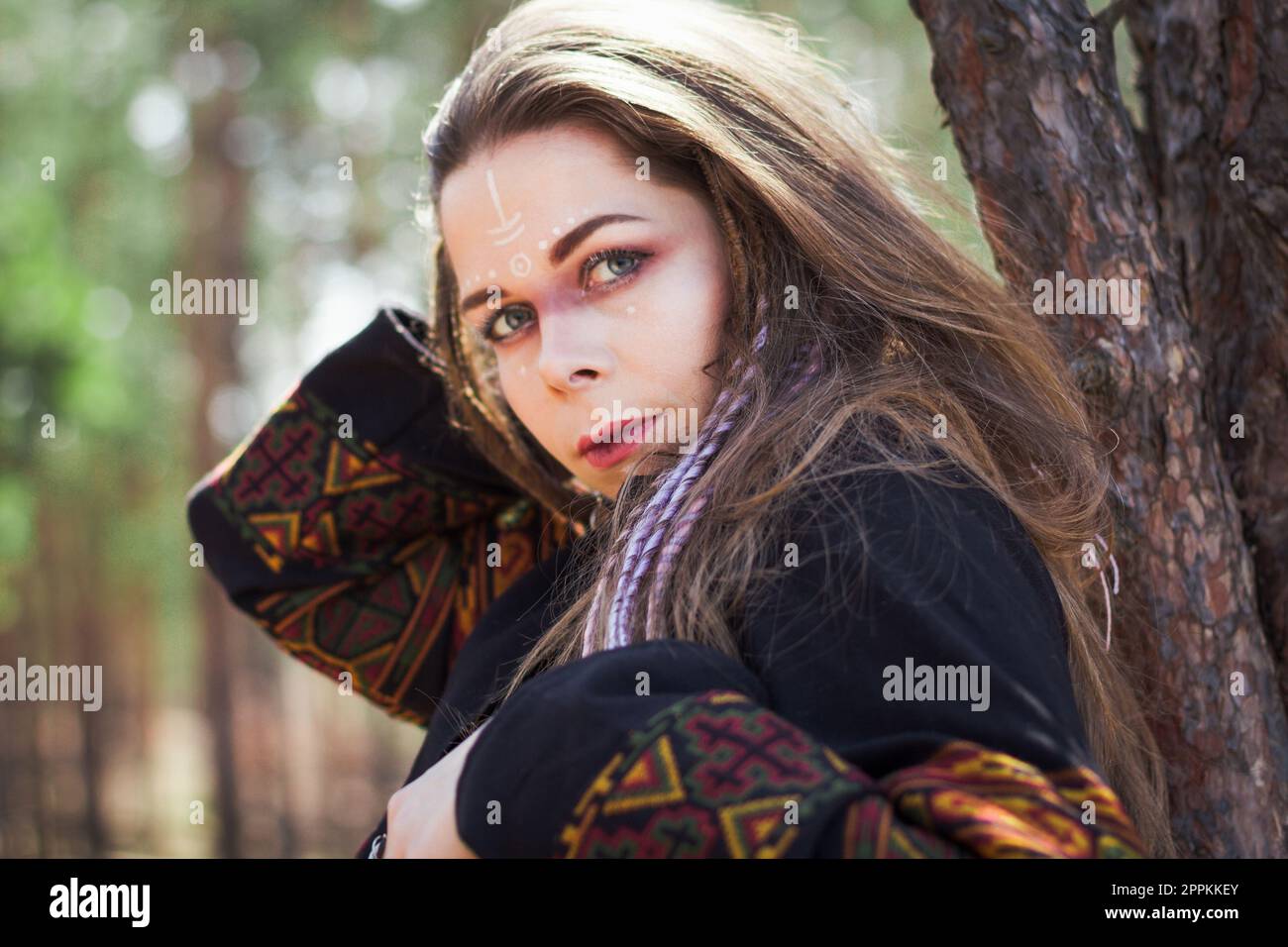 Gros plan jeune femme avec le maquillage de chaman appuyé sur l'image de portrait d'arbre Banque D'Images