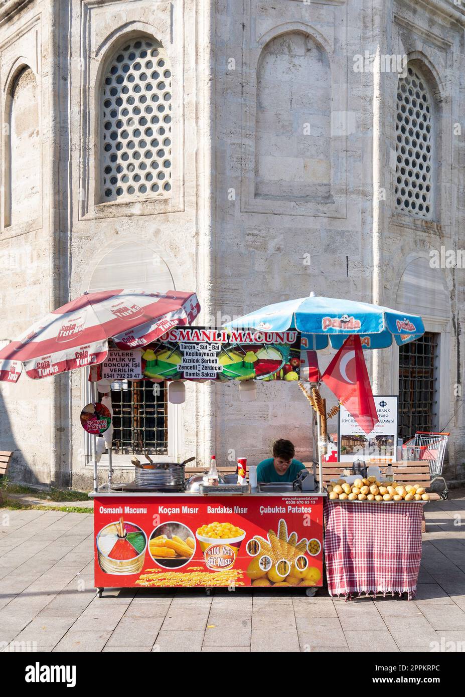 Jeune homme vendant du maïs, des pommes de terre et de la crème glacée sur un chariot traditionnel de restauration rapide dans le district d'Eyupsultan, Istanbul, Turquie Banque D'Images