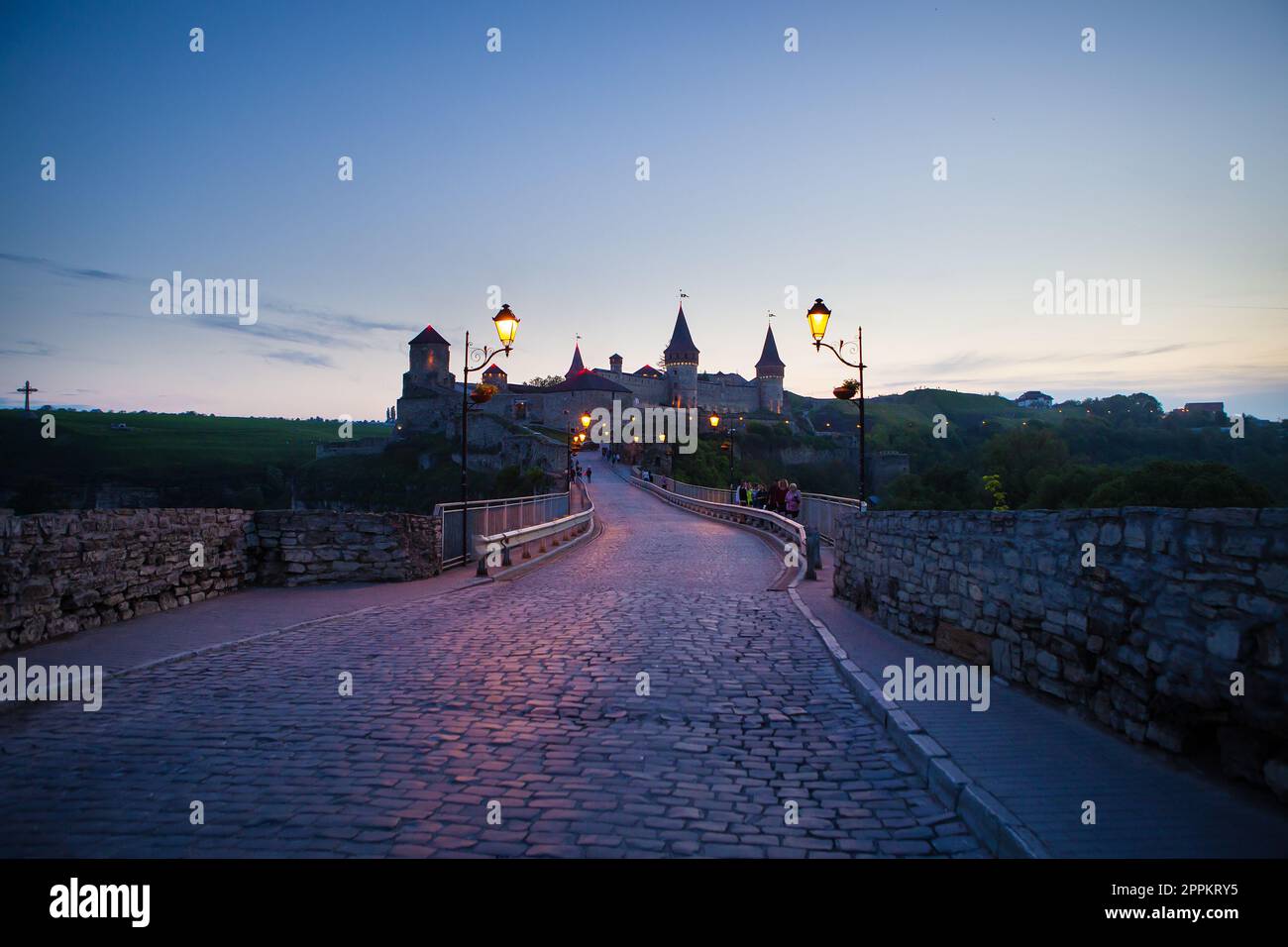 Kamianets-Podilskyi est une ville romantique, une belle vue sur la ville du soir, des lanternes illuminent le pont. Une vue estivale pittoresque de l'ancien château-forteresse à Kamianets-Podilskyi, région de Khmelnytskyi, Ukraine. Banque D'Images