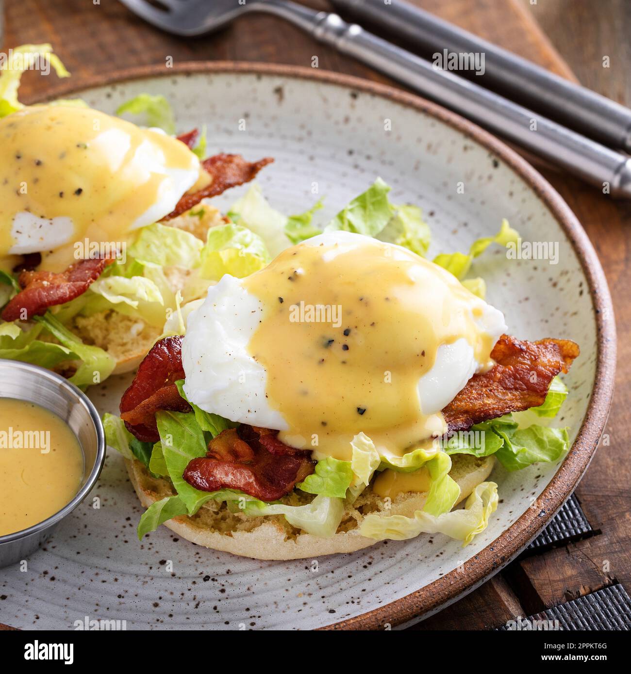 Œufs Bénédicte avec bacon et laitue sur les muffins anglais avec hollandaise, idée traditionnelle de petit déjeuner Banque D'Images
