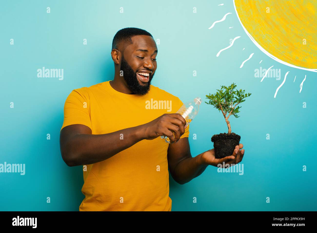 Garçon heureux d'arroser un petit arbre prêts à être plantés. Concept de reboisement Banque D'Images
