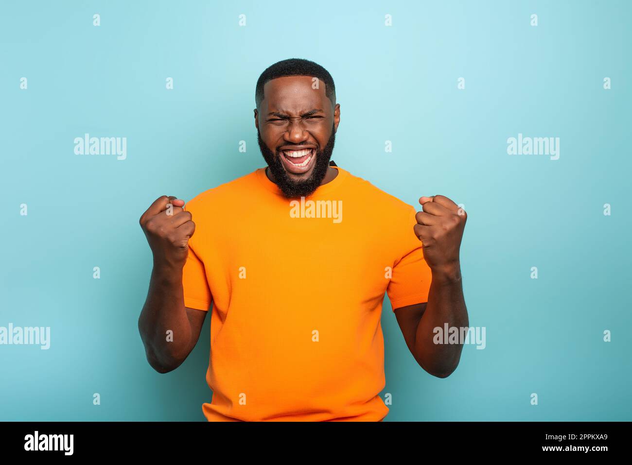Garçon gagne quelque chose. L'étonnement et la surprise face à l'expression. Fond bleu clair Banque D'Images