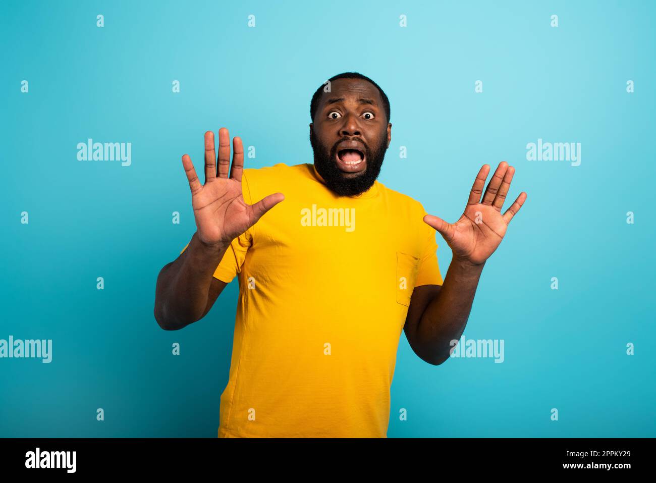 Expression craintive d'un garçon qui a peur de attraper le coronavirus. Arrière-plan cyan. Banque D'Images