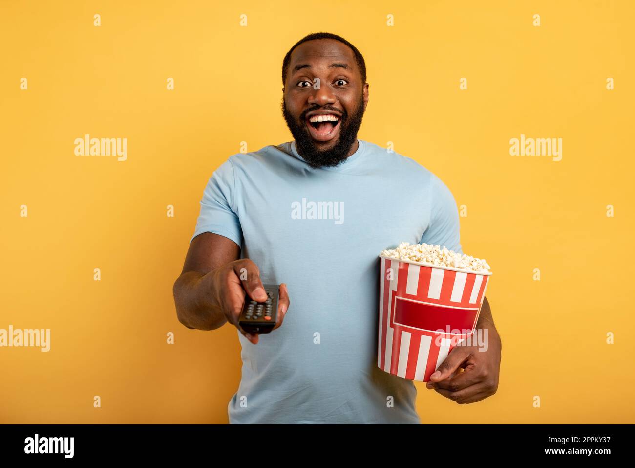Garçon a plaisir à regarder un film. Concept de divertissement et de diffusion en continu de la télévision. Fond rouge Banque D'Images
