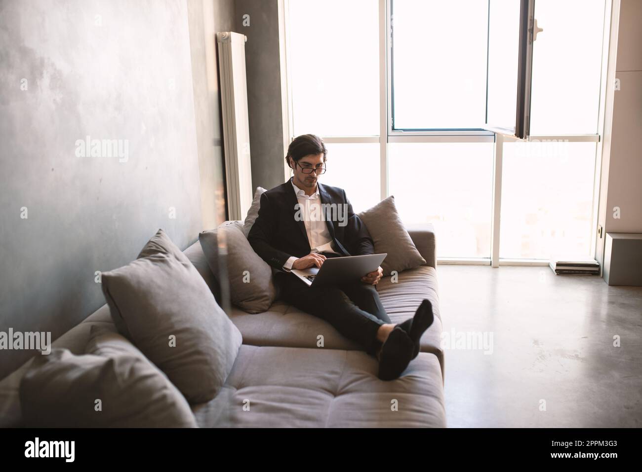 Homme d'affaires travaille à distance à la maison avec un ordinateur portable en raison de la quarantaine du coronavirus. Banque D'Images