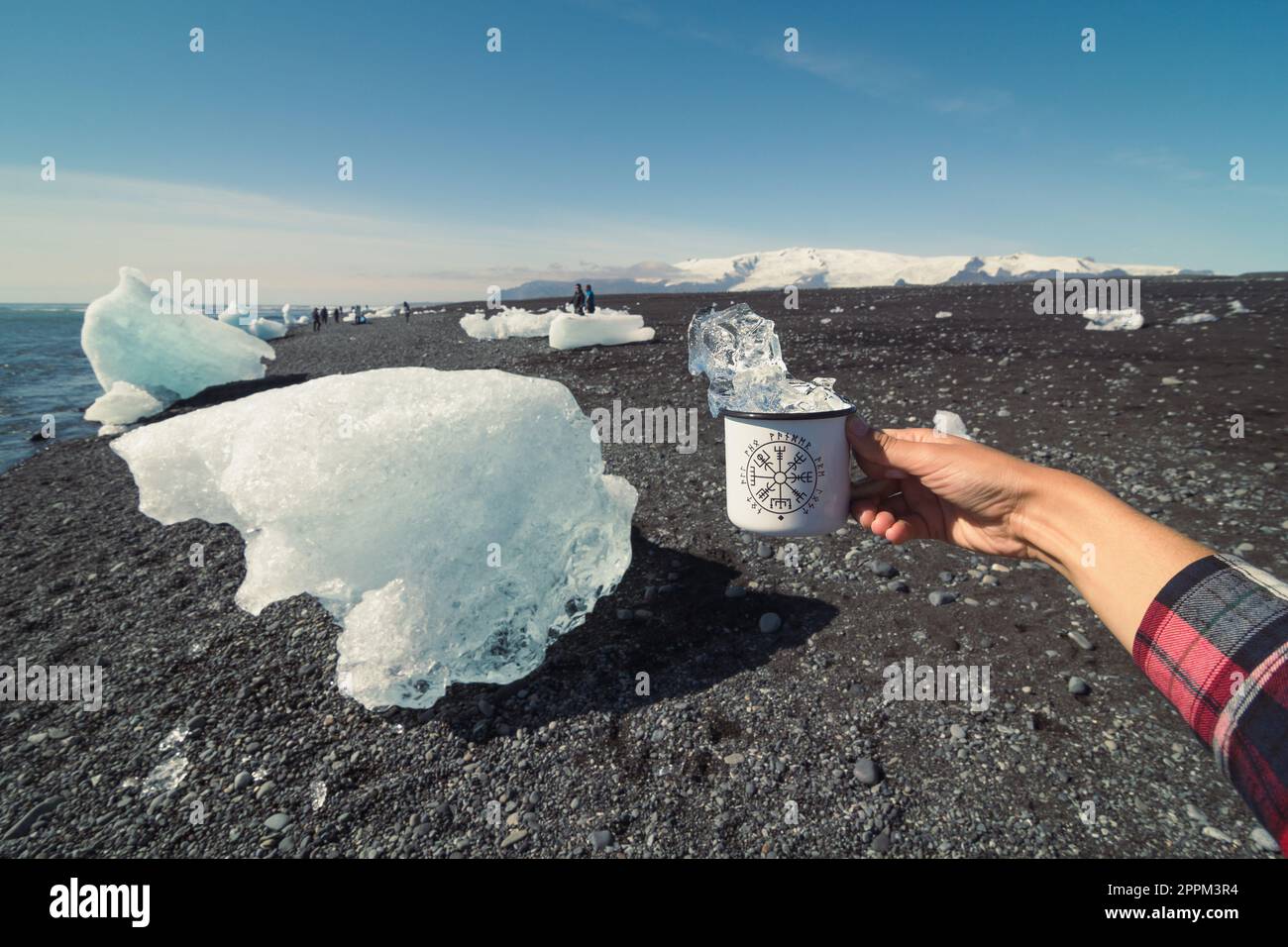 Gros plan touriste tenant une tasse avec de la glace sur la plage froide concept photo Banque D'Images