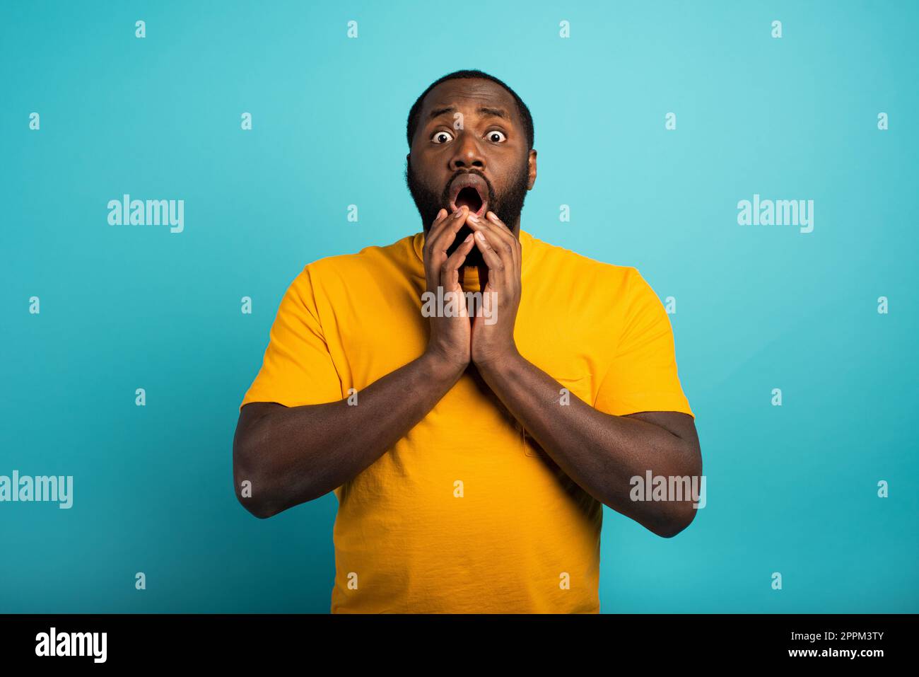 Surpris et choqué expression d'un garçon sur fond cyan Banque D'Images