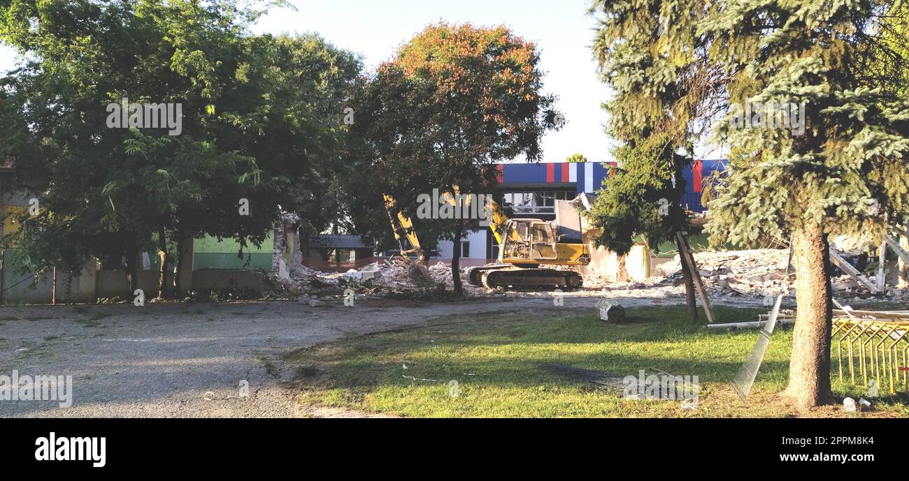 Sremska Mitrovica, Serbie, 13 août 2020. Démantèlement et démolition de l'ancienne école nommée d'après Jovan Popovic. Des morceaux de béton, des barres d'armature sont suspendus. Les bulldozers brisent les murs. Banque D'Images