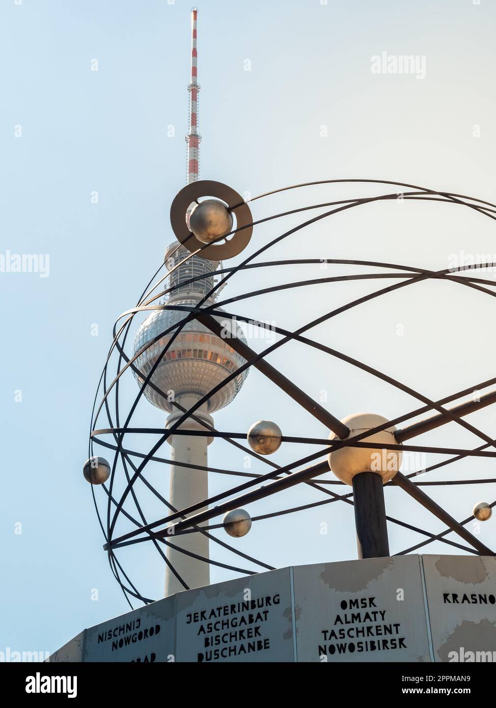 Célèbre tour de télévision de Berlin, tour d'observation avec horloge mondiale et sculpture de plantes en face, vue de bas angle pendant le coucher du soleil, ciel clair Banque D'Images