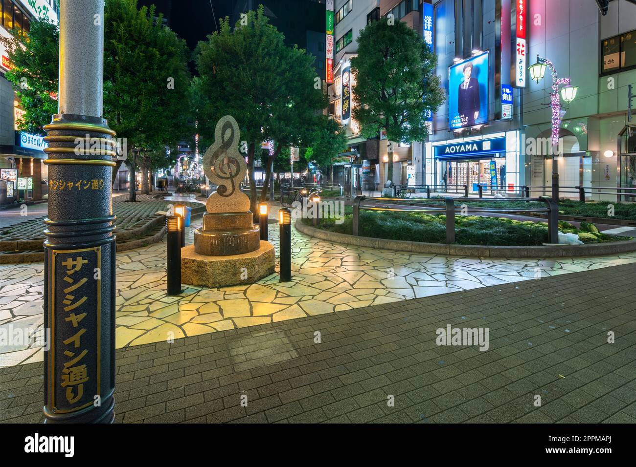 ikebukuro, japon - décembre 31 2012 : lampadaire de Sunshine Street devant un monument en marbre en forme de clef triple à la sortie est de la gare d'Ikebukuro à Tokyo la nuit. Banque D'Images