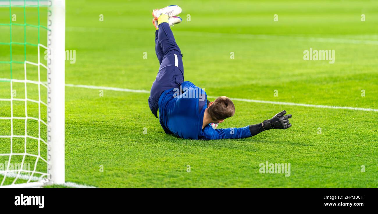 le gardien de but saisit le ballon dans le but d'un match de football Banque D'Images
