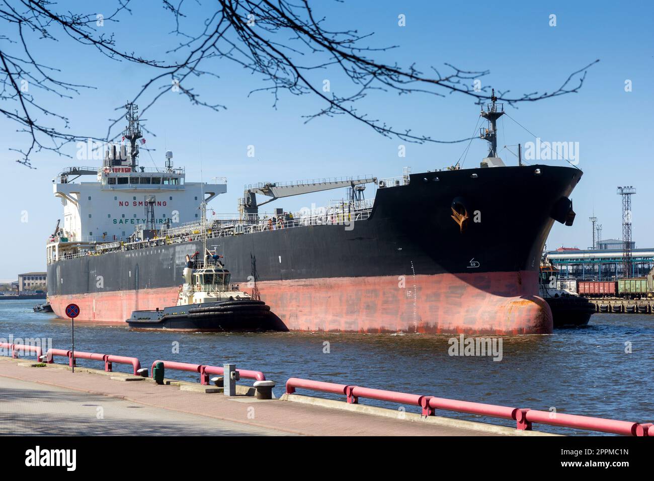 Trois bottes en remorqueur poussant un gros navire Banque D'Images