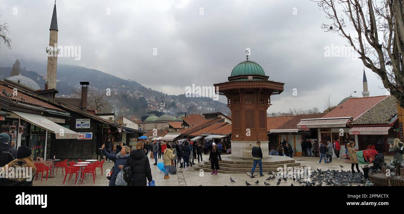 Sarajevo, Bosnie-Herzégovine, le 8 mars 2020, les gens marchent dans les rues centrales de Sarajevo pour nourrir les pigeons. Bascarsija et Square. Monuments islamiques et sites touristiques. Les oiseaux marchent sur le trottoir Banque D'Images