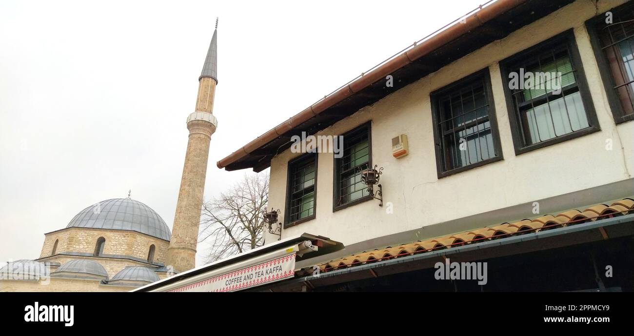 Sarajevo, Bosnie-Herzégovine, 8 mars 2020, ancien bâtiment commercial de style turc avec la mosquée principale et le minaret en arrière-plan. Gazi Husrev-begova dzamija. Tour d'une mosquée Banque D'Images