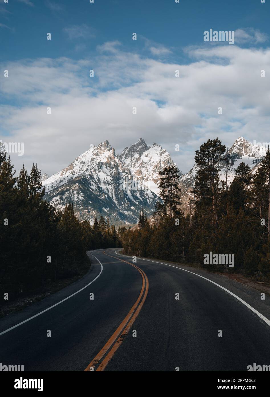 Une route pavée sinueuse menant au domaine skiable de Grand Targhee s'ouvre vers le sommet du Grand Teton au Wyoming. Banque D'Images