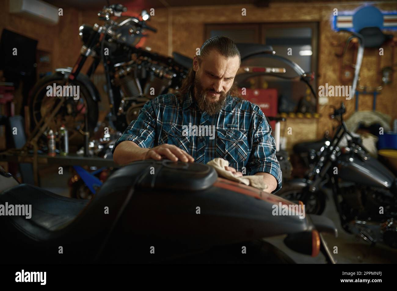 Le week-end, Biker nettoie sa moto dans un atelier de réparation Banque D'Images