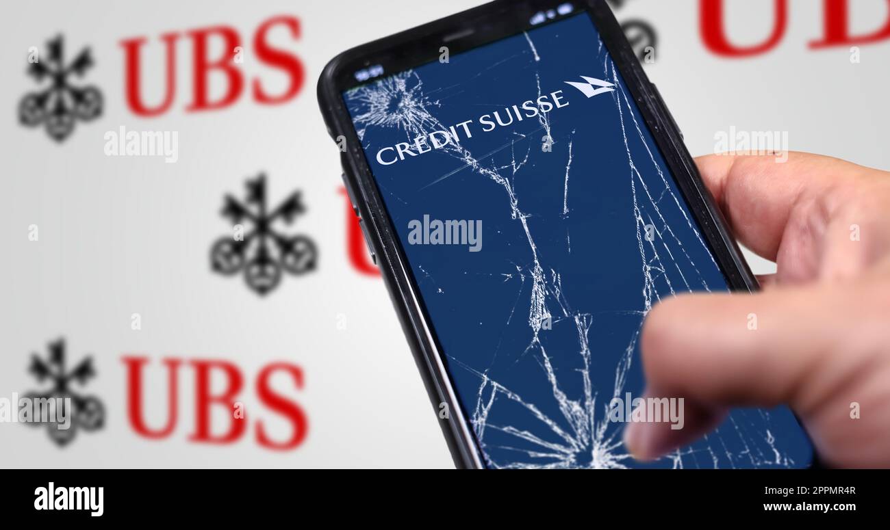 Main tenant un téléphone avec le logo du Credit Suisse sur l'écran fissuré Banque D'Images