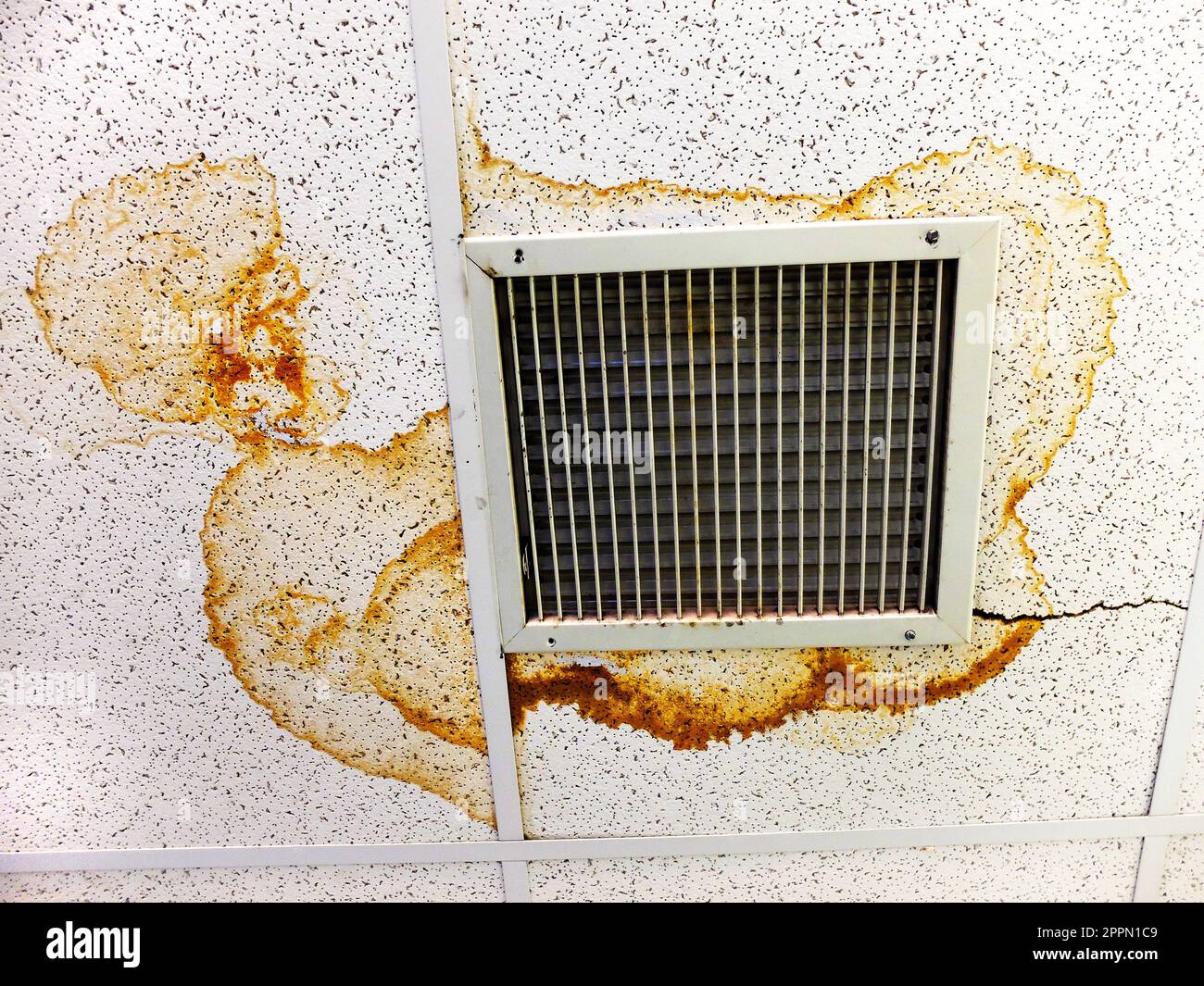 Dégâts d'eau et taches sur les carreaux de plafond par l'évent d'air Banque D'Images