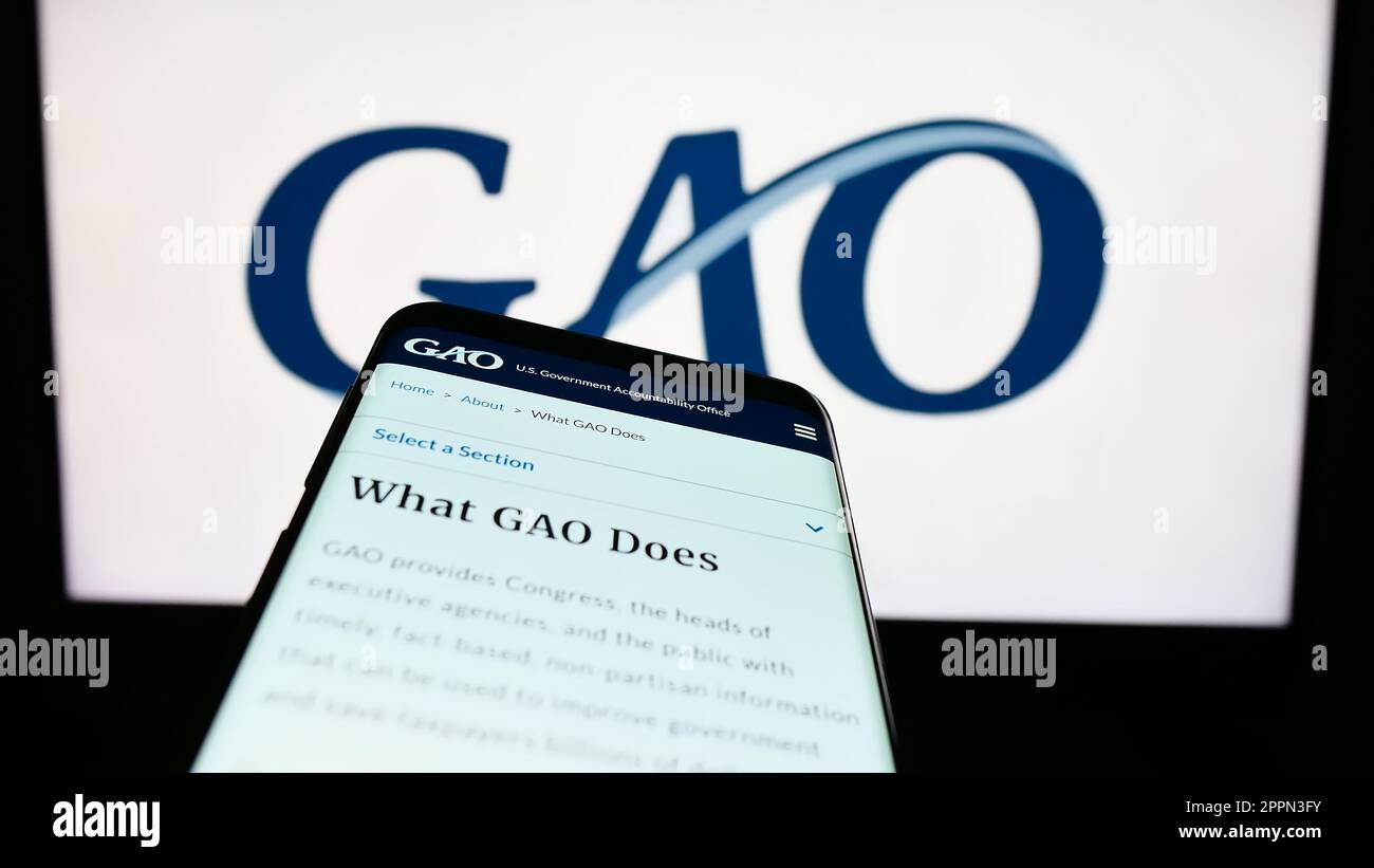 Téléphone mobile avec le site Web du GAO (Government Accountability Office) des États-Unis à l'écran, devant le logo. Faites la mise au point dans le coin supérieur gauche de l'écran du téléphone. Banque D'Images