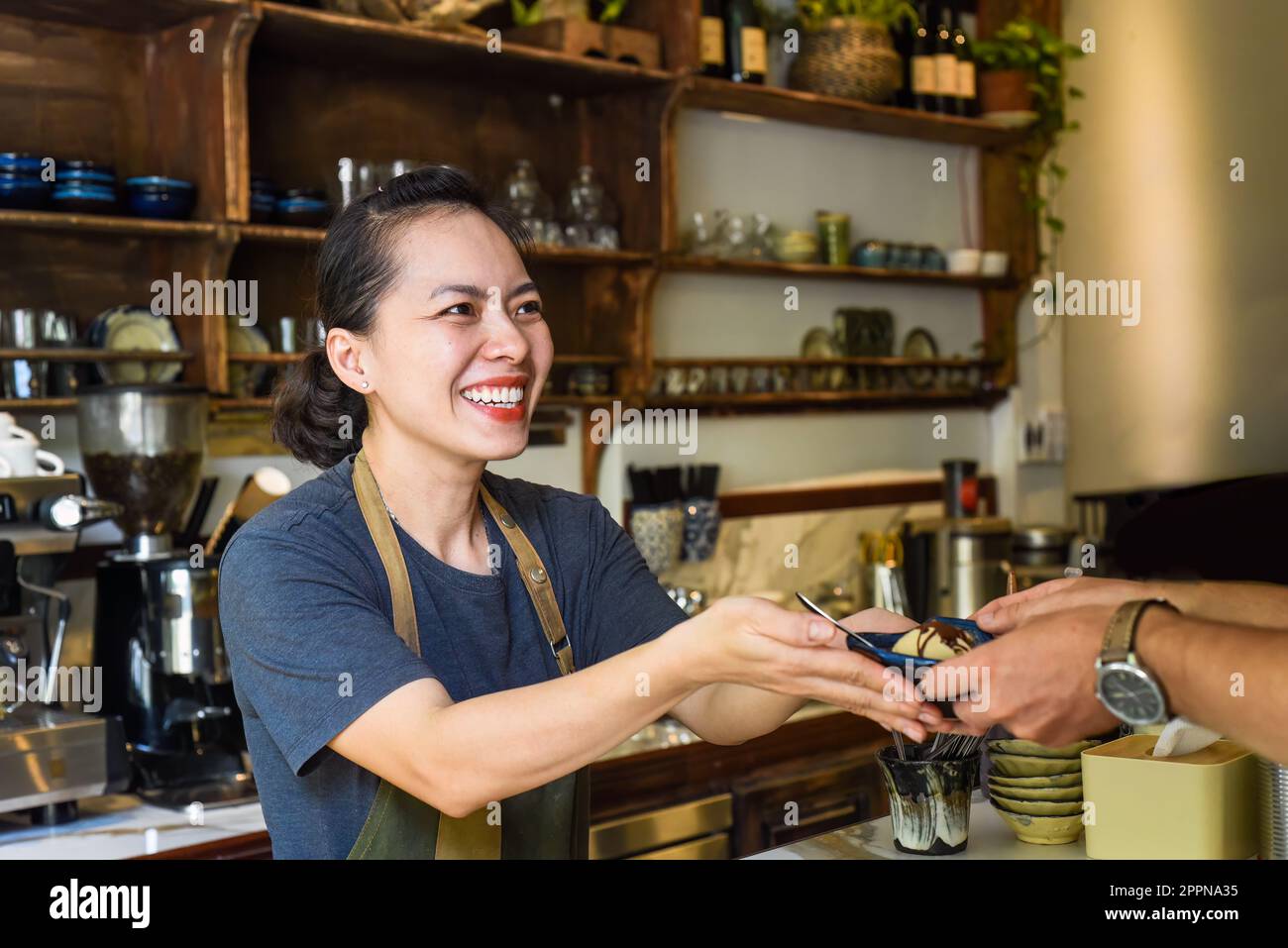 Serveuse vietnamienne servant de la crème glacée pour un client dans un café Banque D'Images