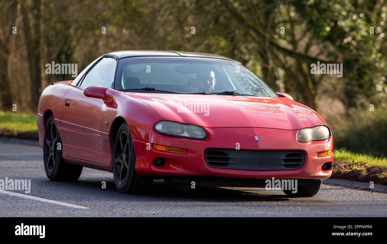 Bicester, Oxon, Royaume-Uni - 23 avril 2023. Camaro 1red de Chevrolet, sans plaque d'immatriculation, conduite sur une route de campagne anglaise Banque D'Images