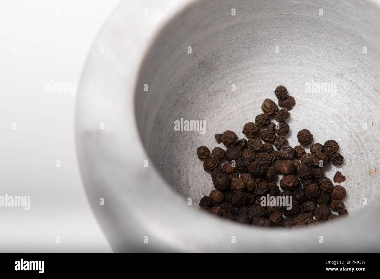 Black Pepper Corns en Mortar et pilon Banque D'Images