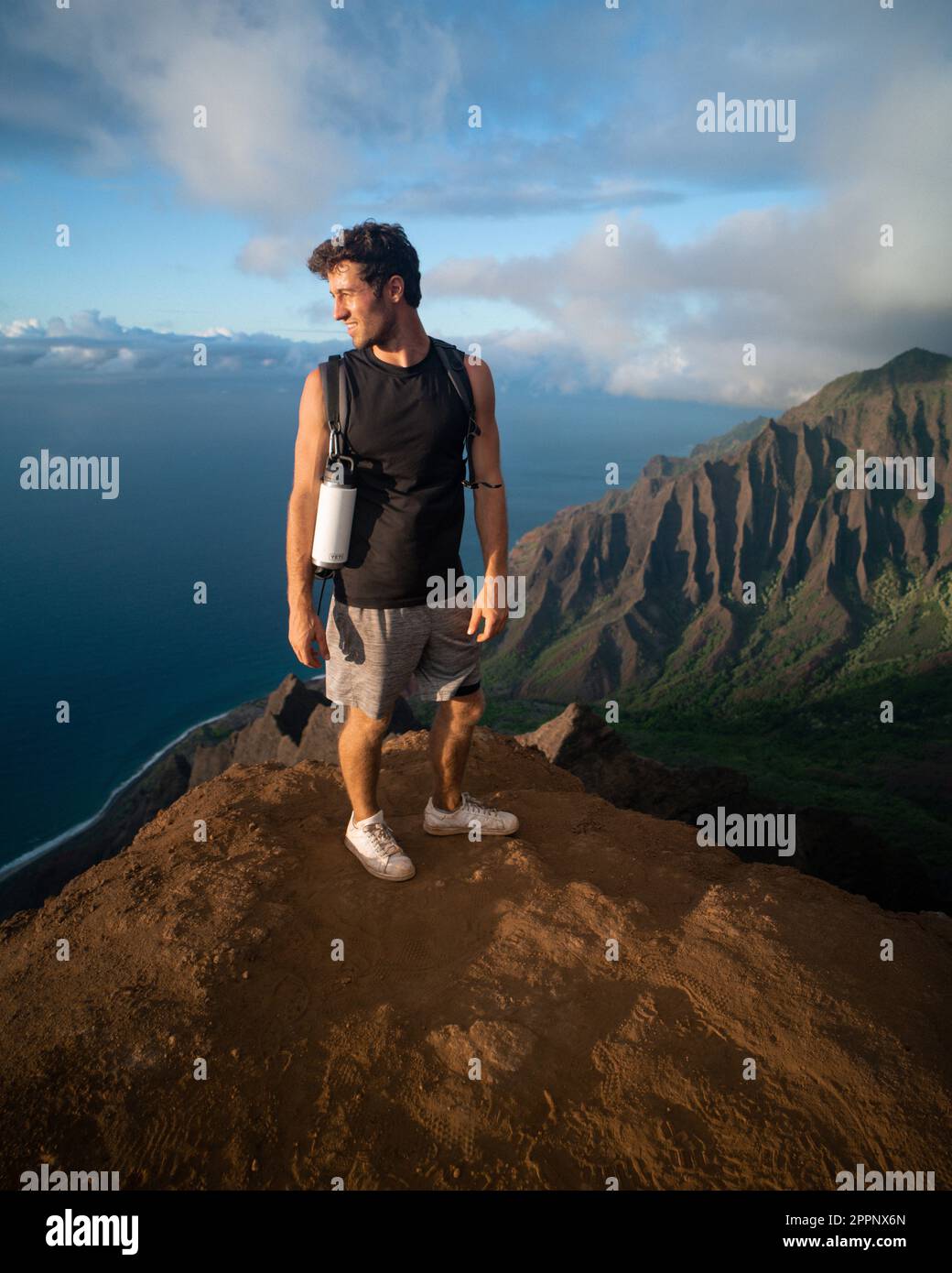 Homme en randonnée jusqu'au sommet du parc national de la côte de Na Pali à Kauai, Hawaï au coucher du soleil. Photo de haute qualité. Banque D'Images