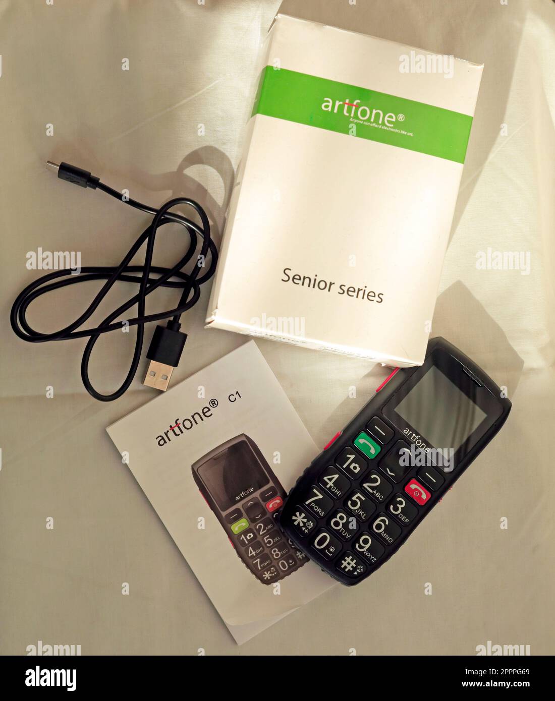 Téléphone portable Artsfone série Senior avec boîtier, câble de chargeur et manuel d'instructions Banque D'Images