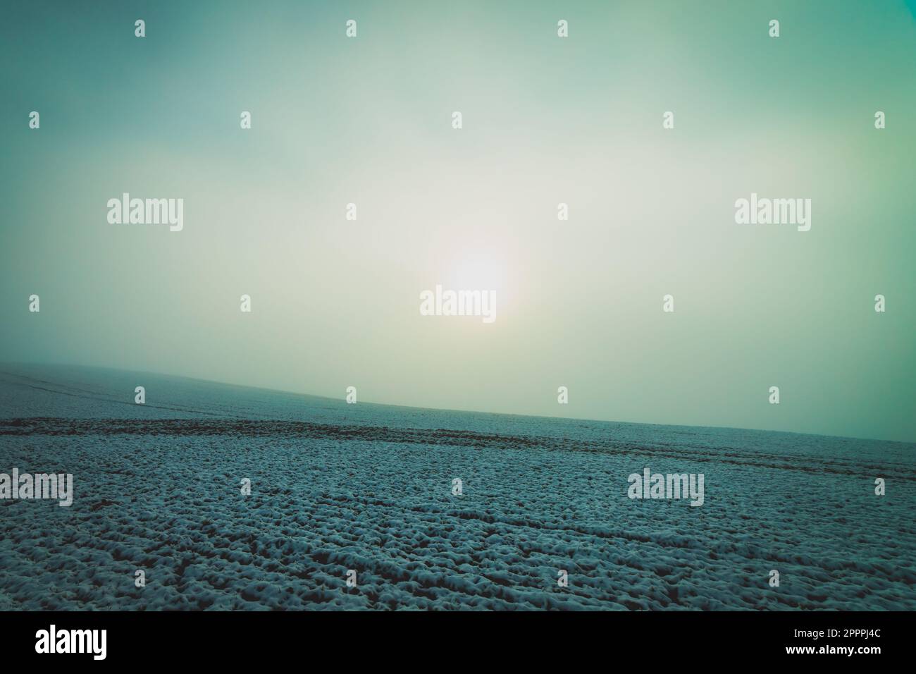 lever de soleil dans le brouillard sur un terrain enneigé Banque D'Images