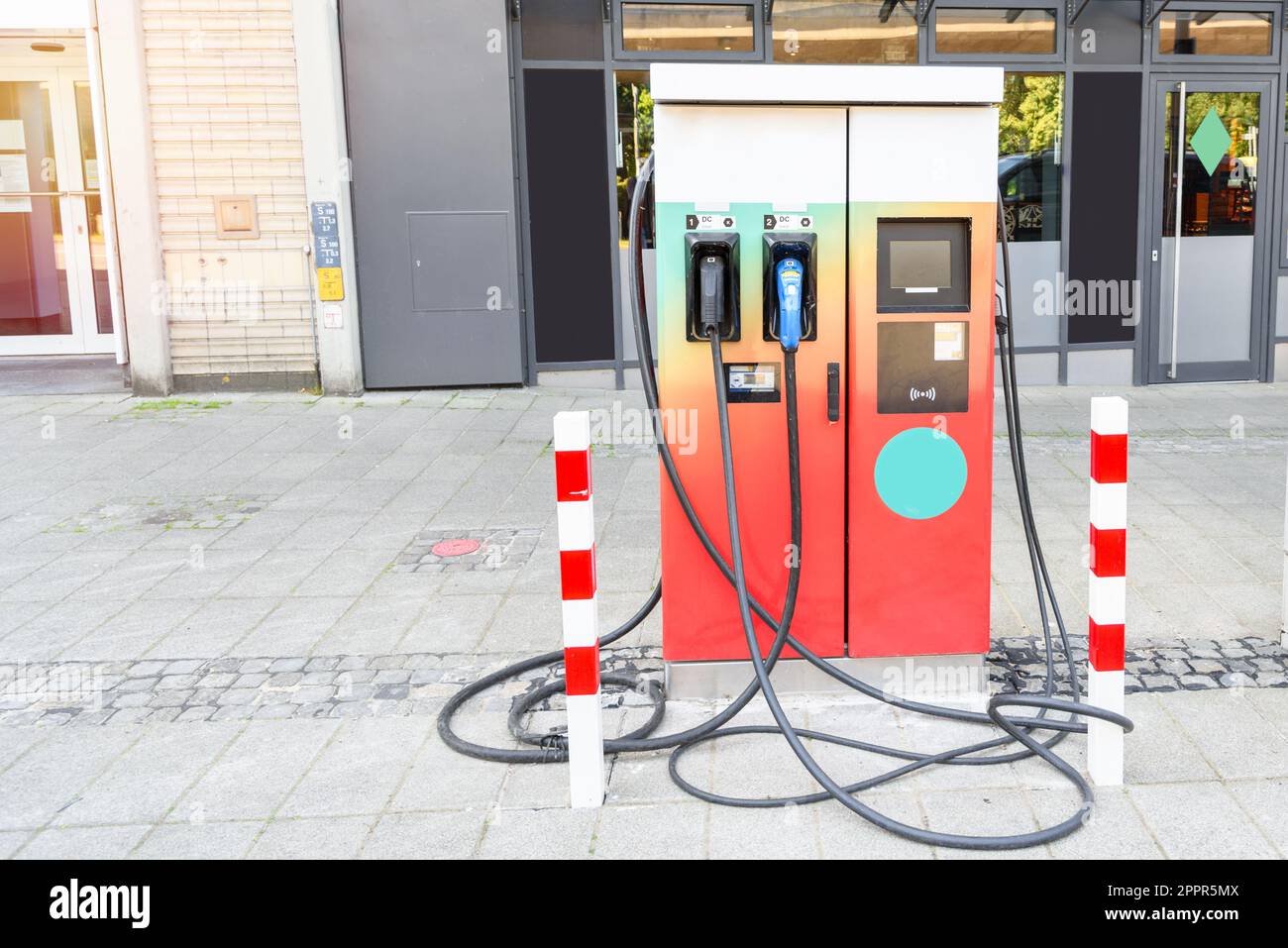 Point de recharge pour voiture électrique sur un trottoir le long d'une rue dans un centre-ville Banque D'Images