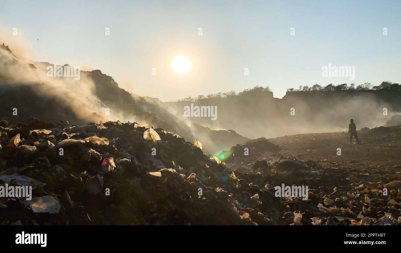 Fumée toxique dans les décharges sanitaires : les travailleurs de l'assainissement trient les déchets en fonction des risques environnementaux Banque D'Images