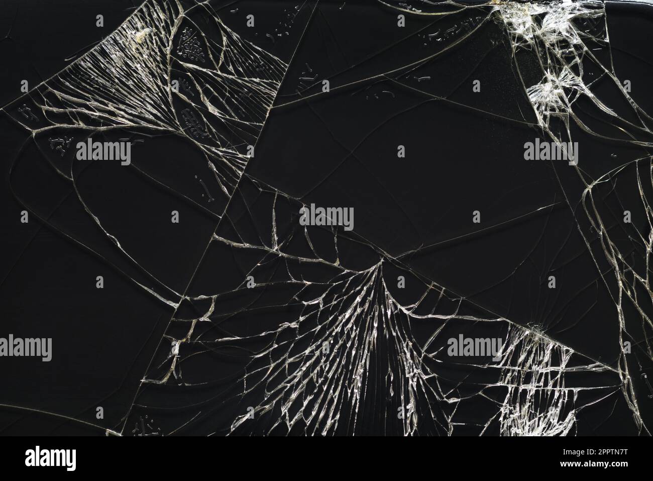 La texture de l'écran du smartphone en verre cassé présente des fissures. Écran noir du téléphone fissuré. Banque D'Images