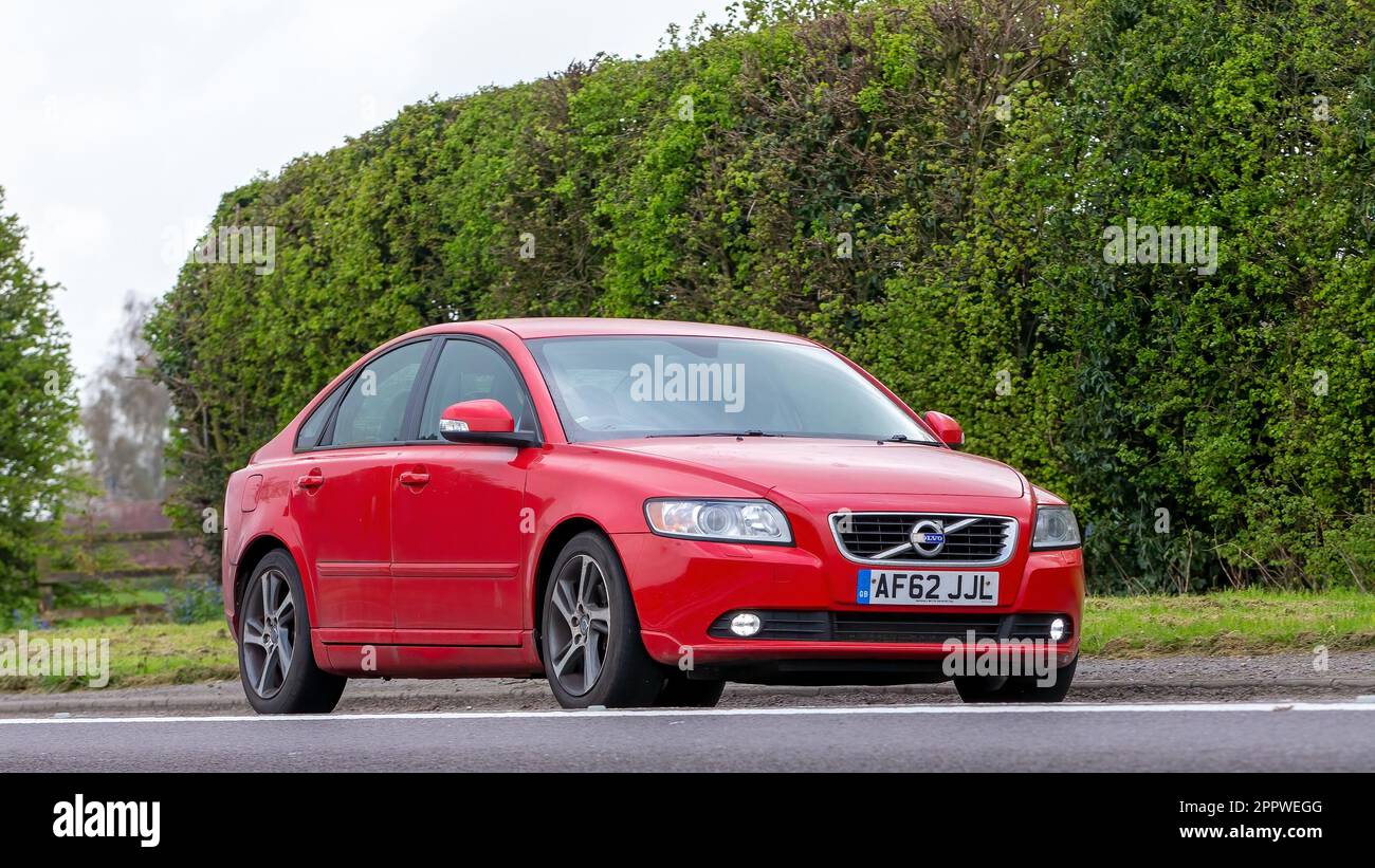 Bicester, Oxon, Royaume-Uni - 23 avril 2023. 2012 Volvo S40 rouge voyageant sur une route de campagne anglaise Banque D'Images