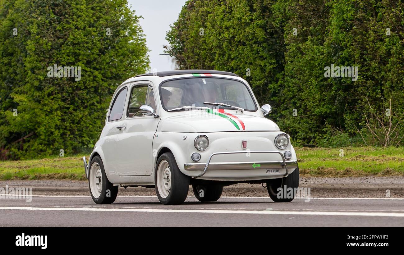 Bicester, Oxon, Royaume-Uni - 23 avril 2023. 1966 Fiat 500 blanc voyageant sur une route de campagne anglaise Banque D'Images