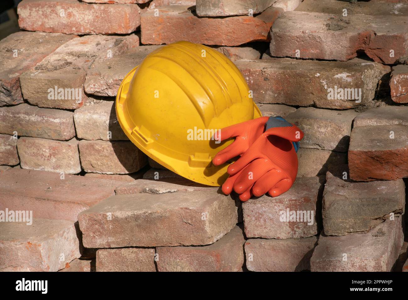travaux sur les chantiers de construction, protection individuelle du casque, du marteau et des gants symbole du travail, charpentiers et ouvriers des chantiers de construction. super bonus Banque D'Images