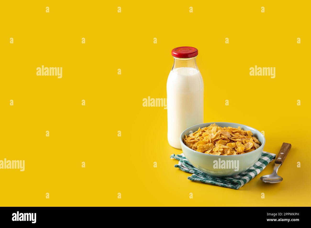 Bol avec céréales et bouteille de lait pour le petit déjeuner sur fond jaune Banque D'Images