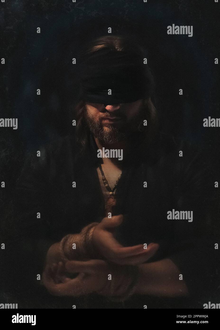 Photo artistique d'un prisonnier aveuglé et mains attachées avec fond noir hommage au roman de Dostoevsky l'Idiot Banque D'Images