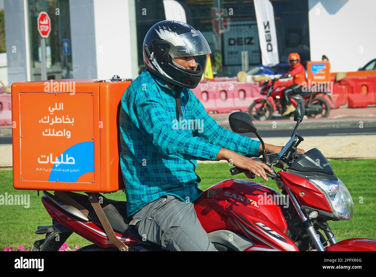 Les travailleurs de la livraison de nourriture de moto au travail dans la rue. Dubaï, Émirats arabes Unis - avril 2023 Banque D'Images